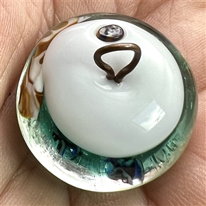 Glass paperweight studio button of fish swimming.