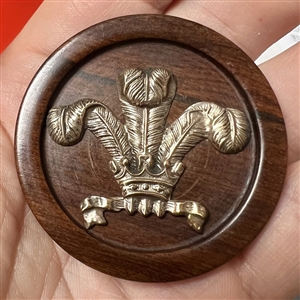 A 19th c Brass Prince of Wales feathers engorged by a crown over wood button.