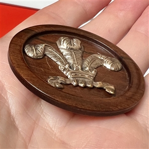 A 19th c Brass Prince of Wales feathers engorged by a crown over wood button.
