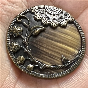 Victorian celluloid button set in tinted brass with flowers and lace.