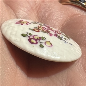 Transitional Mennecy ceramic button of flowers.