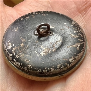 Unusual brass button of a man carrying baskets.