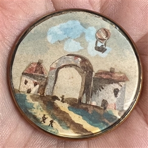 Architectural and hot air balloon scene, gauche on paper under glass set in metal button.