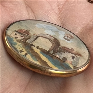 Architectural and hot air balloon scene, gauche on paper under glass set in metal button.