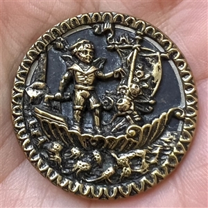 Brass button of a boy in sailboat.