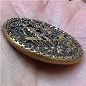 Brass button of a boy in sailboat.