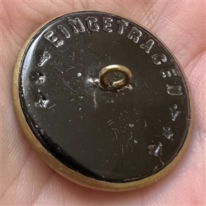 Brass button of a boy in sailboat.