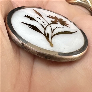 A 19th c. Gold luster painted carnation on white ceramic button.