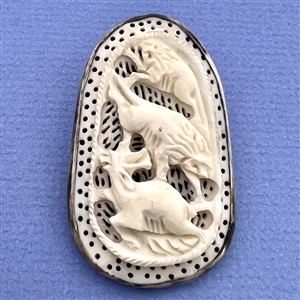 Carved natural material button of lions attacking a deer (?).