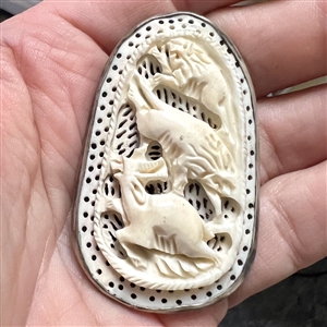 Carved natural material button of lions attacking a deer (?).