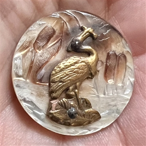 Cameo carved pearl button with cattails and brass heron with fish.