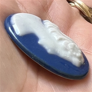 Limoges porcelain oval button of a woman’s head.