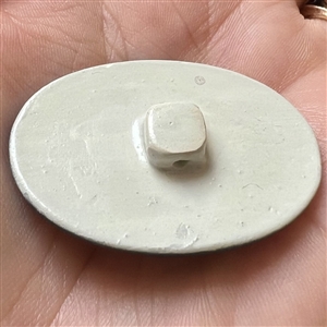 Limoges porcelain oval button of a woman’s head.