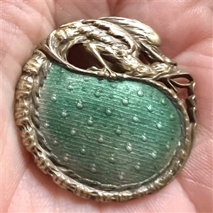 Enamel button with fabulous creature border.