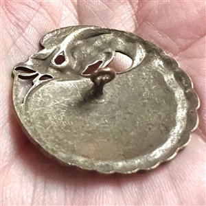 Enamel button with fabulous creature border.