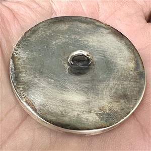 Incised, inked or painted natural material button of an Asian girl with a flower.