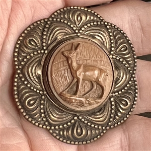 Carved wood deer set in metal button. 