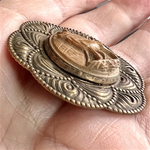 Carved wood deer set in metal button. 