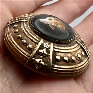 Ceramic button of a dog set in brass.