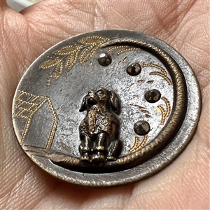 Tinted brass button of a poodle.
