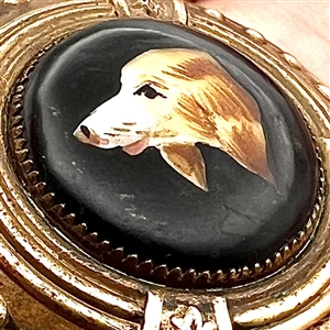Ceramic button of a dog set in brass.
