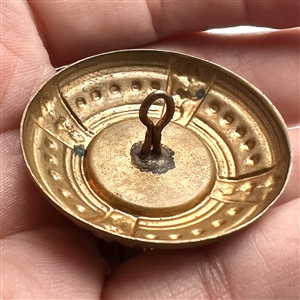 Ceramic button of a dog set in brass.