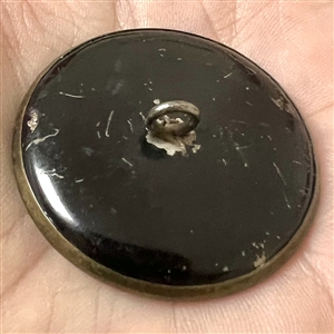 Brass button of Putti holding a torch while riding a griffin.