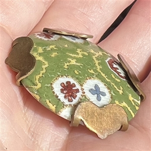 Painted porcelain button set in an unusual brass “spider.
