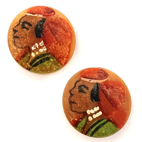 Two painted vegetable ivory buttons of heads.