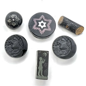 Six black glass buttons, including a tile star. 