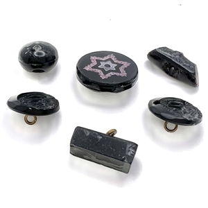 Six black glass buttons, including a tile star. 