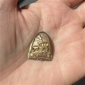 Commemorative button of horse and covered wagon under St. Louis arch. 