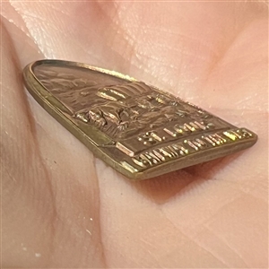 Commemorative button of horse and covered wagon under St. Louis arch. 