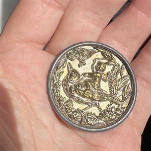 Brass transportation button of  “Riding the Robin.