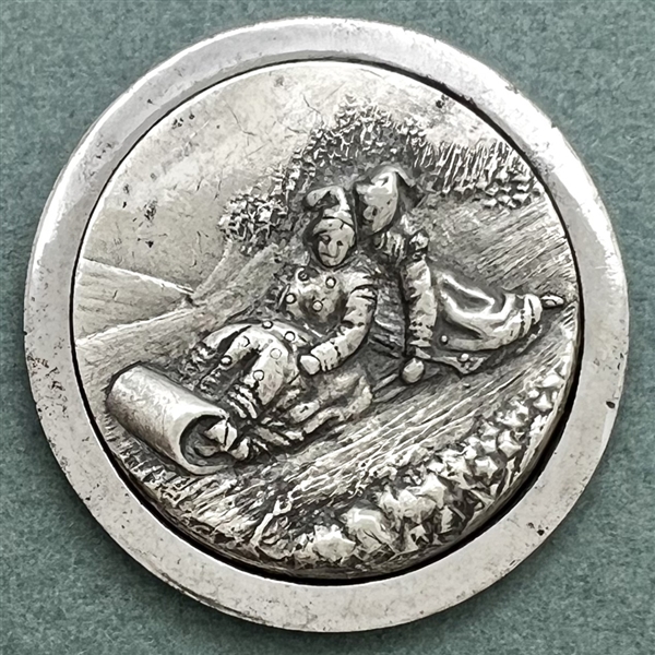 “Toboggan Ride" pewter set in steel-cup button.