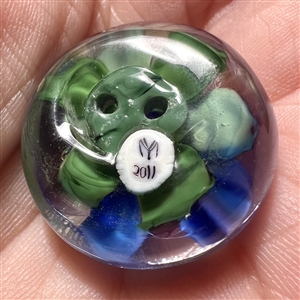 Mary Gaumond's whistle hole glass studio button of a violet.