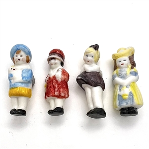 Four painted ceramic buttons of little girls.
