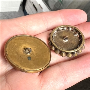 Two blue glass in metal buttons.