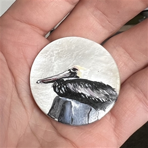 Painted shell studio button of a pelican by Clair Scott. 