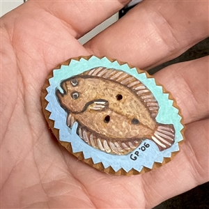 Painted masonite studio button of a flounder fish. 