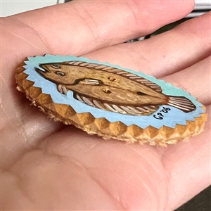 Painted masonite studio button of a flounder fish. 