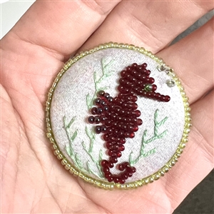 Beaded fabric studio button of a sea horse by Kate McDermott.
