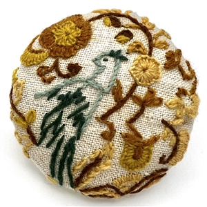 Huge embroidered studio button of bird in a flower garden by Marie Boorum. 