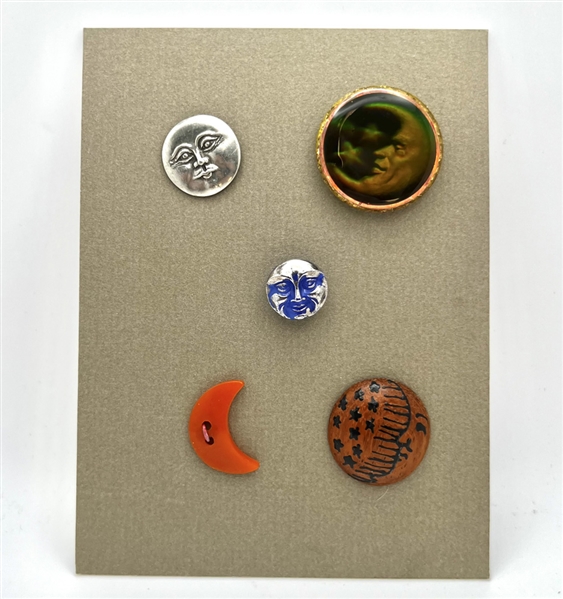 Card of five astronomical buttons including Nancy Dubois hologram crescent man in the moon.