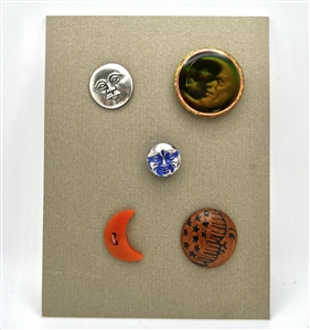 Card of five astronomical buttons including Nancy Dubois hologram crescent man in the moon.