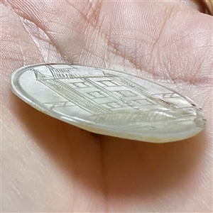 Incised iridescent pearl button of a bridge structure.
