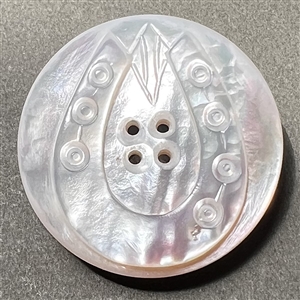 Carved ocean pearl button of a horseshoe.