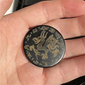 Celluloid (?) button of a dragon with Asian characters.