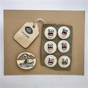 Seven natural material Inuit buttons including a kayaker and a set of six roaring polar bears.