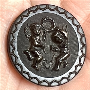Horn button of cherubs dancing with a laurel wreath.